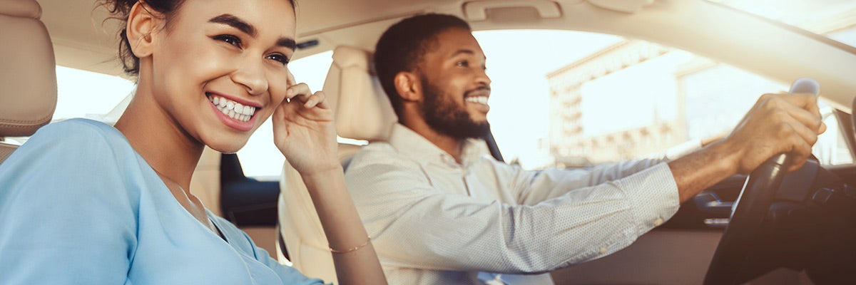Happy african american couple driving in their new car